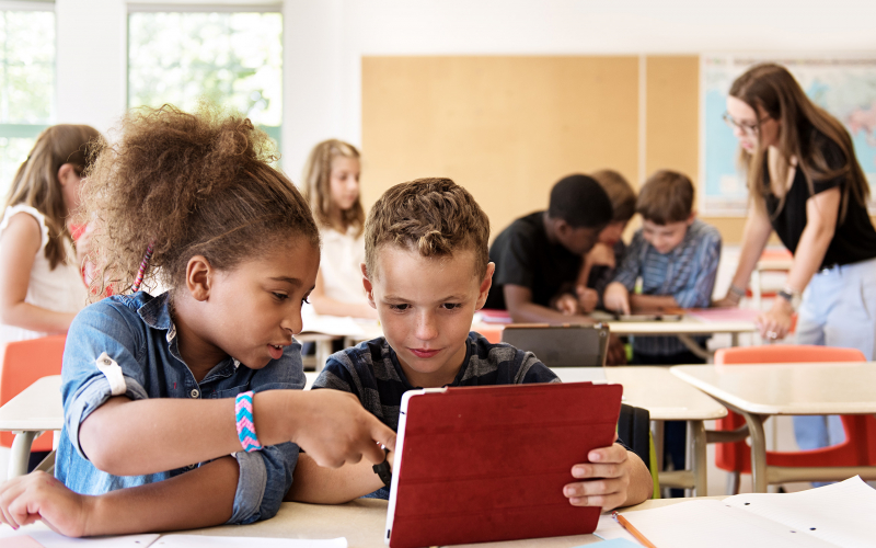 two students in class working on an ipad